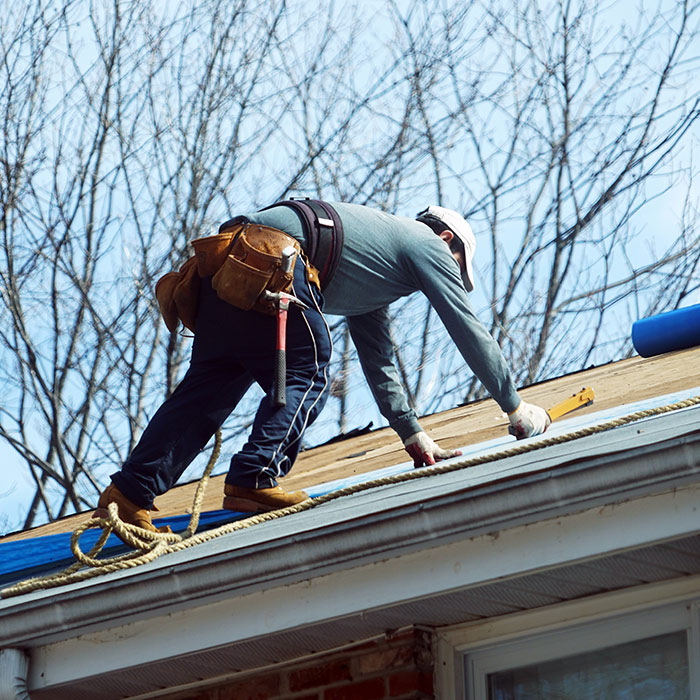 contractor-on-top-of-house-repairing-damaged-roof-taylorsville-nc