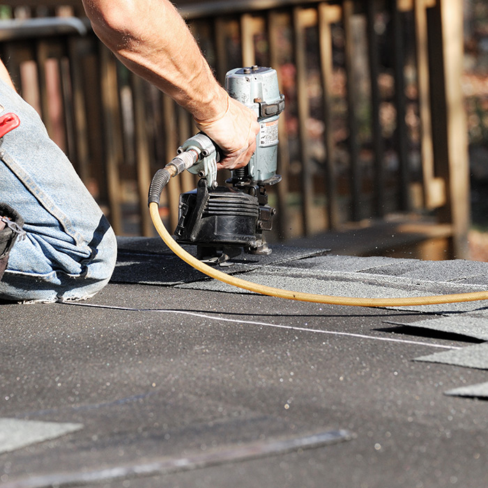 roofer-hand-close-up-with-nailgun-repairing-asphalt-shingles-roof-at-house-taylorsville-nc